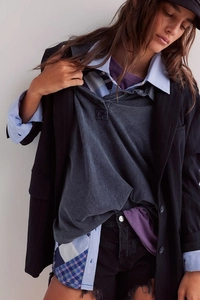 Close-up of layered French casual shirt with diamond pattern stitching and distressed shorts