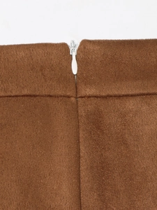 Detail shot of brown suede skirt featuring a high-quality white invisible zipper closure