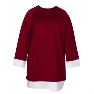 Close-up of deep red plus size top with white layered cuffs and hem detail
