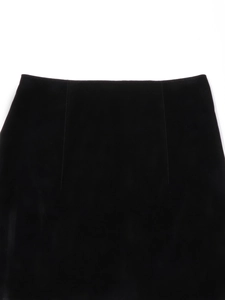 Detailed view of black velvet skirt waistline featuring elegant pleats and precise stitching