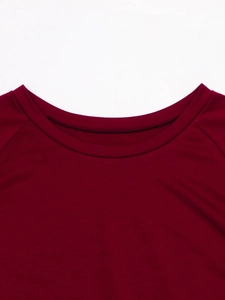 Detail view of burgundy round neck with ribbed finish and raglan sleeve stitching