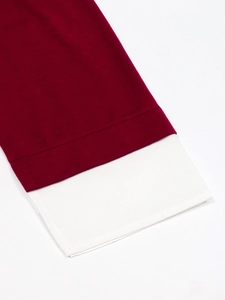 Close-up of ribbed burgundy sleeve with white faux-layered cuff detail and fine stitching