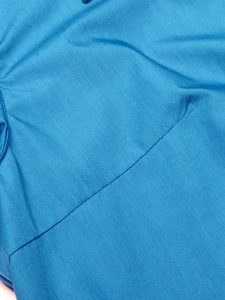 Gros plan d'une chemise bleue en coton et lin montrant les coutures et la texture