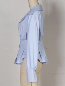 Détail de chemise rayée bleue à plis à la taille et col en pointe élégant