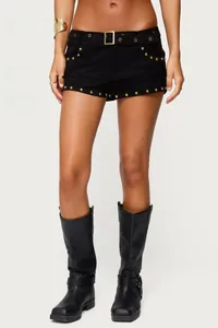 Details der Wildleder-Hotpants mit goldenen Nieten und Schnalle sowie Lederstiefeln