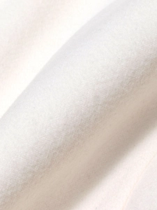 Macro shot of ivory white soft brushed wool fabric texture on the elegant blazer