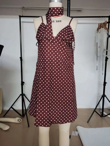 Detailansicht eines braunen Polka-Dot-Kleides mit V-Ausschnitt und passendem Halstuch