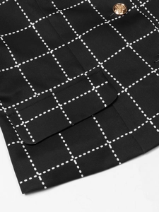 Detail of houndstooth jacket featuring a golden embossed button and a neat pocket flap