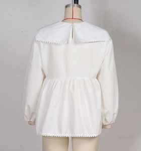 Detail of white cotton shirt showing wide lace-trimmed Peter Pan collar and puffy pleats