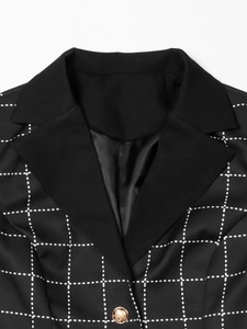 Detail of houndstooth jacket featuring a black lapel and embossed gold metal button
