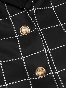 Detailed macro view of black fabric texture with gold crest buttons and white grid pattern