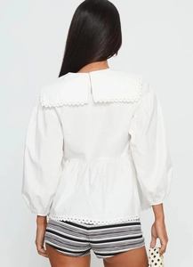 Detail of white cotton shirt featuring a large Peter Pan collar with hollow lace embroidery