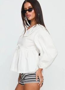 Detail of white Peter Pan collar shirt with lace embroidery and drawstring waist