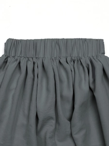Détail d'une jupe gris anthracite à taille haute élastique avec des plis fluides