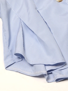 Détail de l'ourlet de chemise à rayures bleues et blanches avec couture et bouton