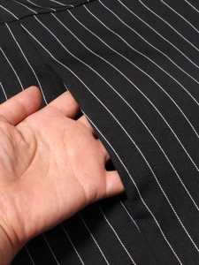 Detailed close-up of side pocket and twill texture on black and white striped dress