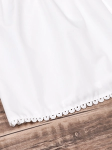Detail of scalloped lace edge on a white long sleeve blouse for women with cotton texture