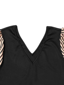 Detail of deep V-neckline and striped ruched sleeves on a slim fit black dress