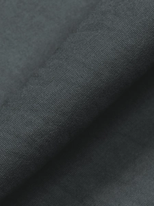 Détail macro de la texture tissée gris anthracite et des plis d'une jupe trapèze