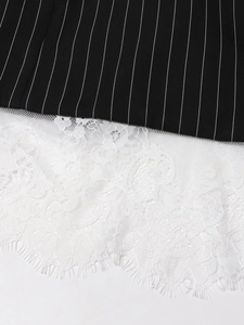 Detailed close-up of vertical striped fabric with delicate white floral eyelash lace hem