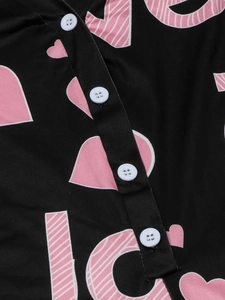 Close-up of black romper with pink hearts and LOVE print featuring four white buttons