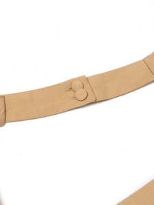 Dettaglio di una cintura in tessuto beige chiaro con due bottoni rivestiti abbinati e cuciture fini