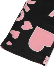 Close-up of pink heart and letter prints on black knit fabric with double-needle stitching