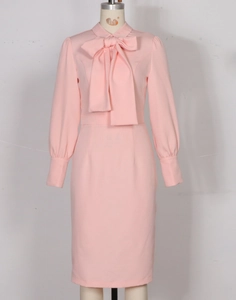 Detail of light pink fitted dress featuring a large bow neckline and lantern sleeves