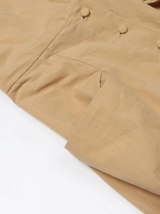 Dettaglio del tessuto kaki in lino con bottoni coordinati e cuciture rinforzate