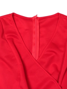 Detail of red V-neck evening dress showing the concealed zipper and fine knit texture