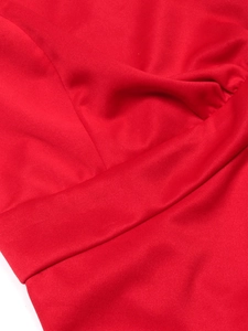 Detail of red knit dress showing high-quality stitching and textured fabric fold