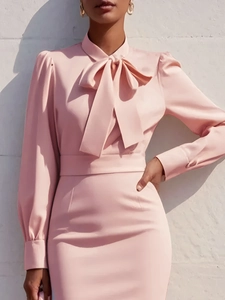 Close-up detail of the elegant pink satin dress with bow tie collar and puff sleeves