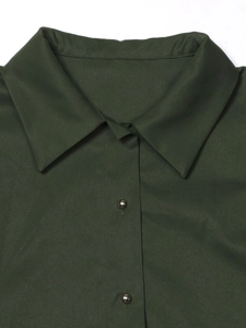 Close-up of dark green shirt dress featuring classic lapels and silver ball metal buttons