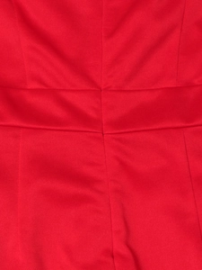 Macro view of waistline stitching and pleat details on the elegant red maxi dress