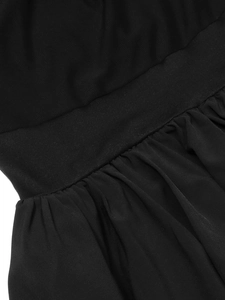 Detail view of black dress featuring breathable mesh fabric and pleated skirt textures