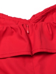 Detail of red evening dress showing the invisible zipper and ruffled neckline craftsmanship
