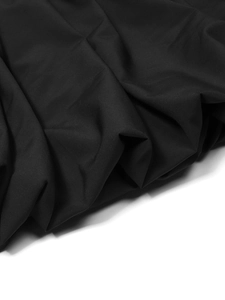 Detail shot showing the pleated texture and drapery of black mesh fabric on the dress