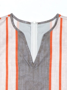 Detail of V-neckline with back zipper on orange and taupe vertical striped jumpsuit