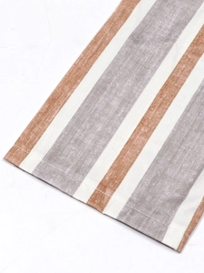 Detail of striped fabric texture and precision stitching on the hem of a long dress