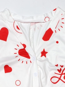 Close-up of V-neck jumpsuit with red heart and Love prints showing button details
