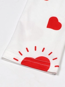Detail of white knit fabric cuff showing red heart prints and double needle stitching