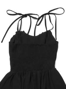 Details der verstellbaren Bindeträger und des gesmokten Rückendesigns am schwarzen Kleid
