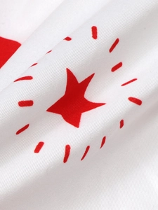 Close-up of white twill fabric with vibrant red star print and textured weave detail