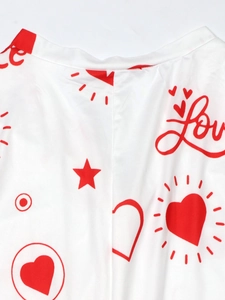 Close-up of knit fabric showing red Love text and heart print details for white jumpsuit