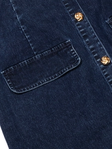 Gros plan d'une robe en jean bleu foncé avec boutons dorés et détail de poche à rabat