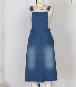 Detail of blue denim midi dress showing front utility pocket and adjustable straps