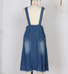 Detail view of denim overall dress back with faded wash effect and frayed hemline