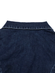 Détail du col en denim bleu indigo avec surpiqûres et texture de tissu robuste