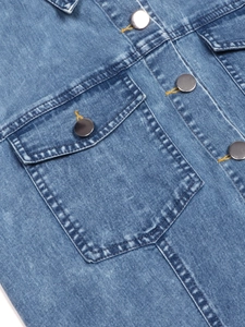 Detail of blue denim dress featuring silver metal buttons and yellow contrast stitching