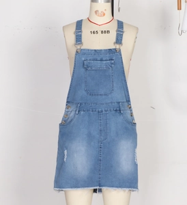 Detail of light blue denim overall skirt showing adjustable buckles and chest pocket
